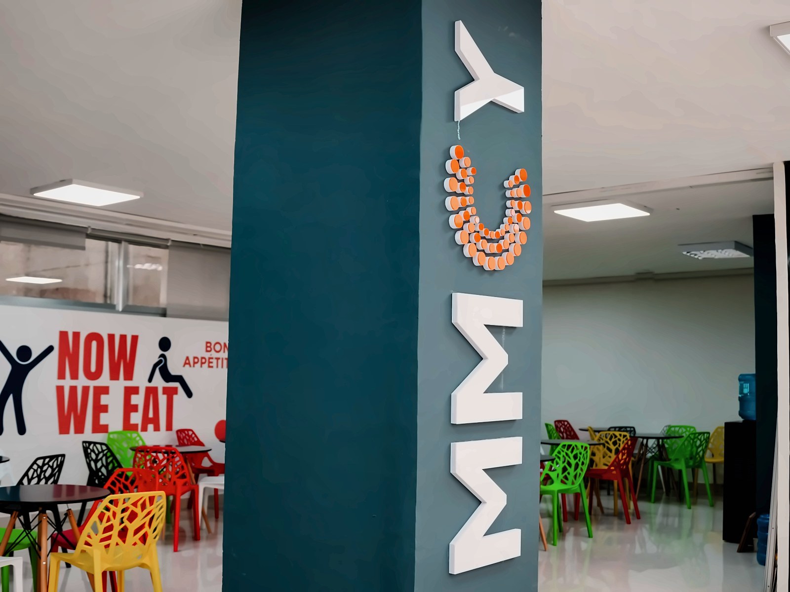 MMCY dimensional logo on a teal pillar in the staff canteen